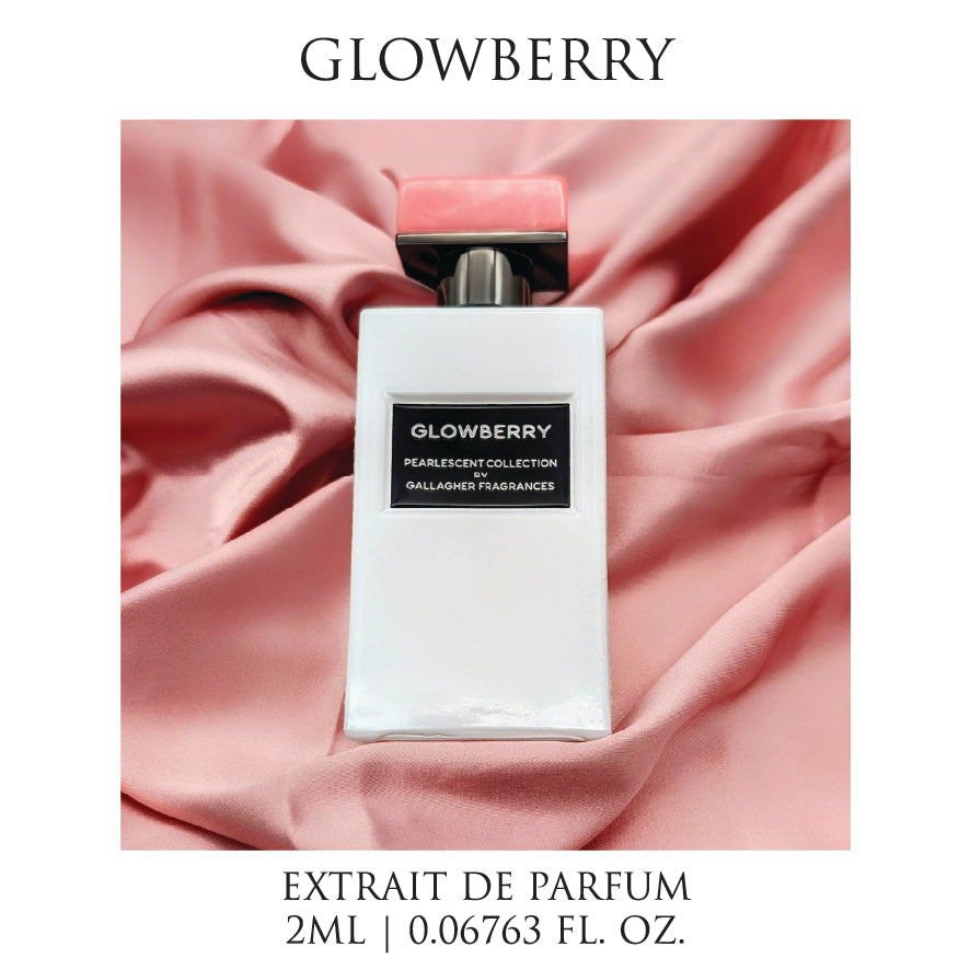 A bottle of Glowberry perfume with a white body and pink cap, labeled with the brand's name and the scent notes. The bottle is presented against a pink fabric background.